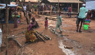 Des personnes déplacées, suite à l'incendie du camp d'Élevage, remplissent des jerricans à un point d'eau dans l'enceinte de la mosquée de Bamabri. République centrafricaine. 2021. 