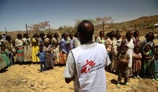 Un employé MSF auprès des femmes qui attendent avec leurs enfants une consultation médicale dans une clinique mobile du village d'Adiftaw, dans la région nord éthiopienne du Tigré.