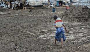 Une jeune fille rapporte un jerrican d'eau dans son abri du camp d'Al Tanideba au Soudan. 2021.