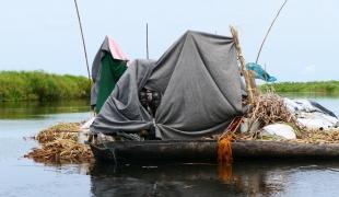 Une famille déplacée a utilisé des couvertures et des bâches en plastique pour construire un abri 