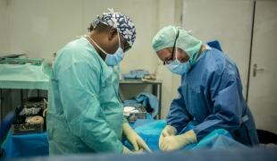 Deux chirurgiens effectuent une amputation à l'hôpital MSF de Tabarre. Haïti. 2020. 