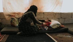 Une femme prend soin de sa fille dans la tente d'un camp de personnes déplacées. Nord-ouest de la Syrie. 2022.