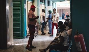 Un membre du personnel soignant parle aux patients dans la zone de triage du centre d'urgence MSF de Turgeau. 