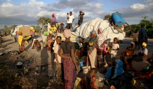 Des personnes déplacées par le conflit à Cabo Delgado attendent à côté d'un camion à la périphérie de Mueda. Ils avaient auparavant été réinstallés dans d'autres zones de la province mais visent maintenant à rejoindre Palma, une ville côtière qui a été attaquée plus tôt cette année et où certaines personnes sont déjà progressivement revenues