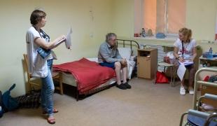 Deux membres des équipes MSF dans la chambre d'un patient qui a trouvé refuge dans un centre pour personnes déplacées à Dnipro. Ukraine. Juin 2022.