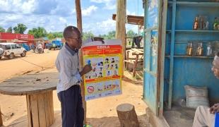 Un promoteur de santé MSF en discussion avec le propriétaire d'un commerce à Madudu, à proximité de l'épicentre de l'épidémie d'Ebola. Ouganda. 2022.