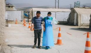 Un travailleur de santé accompagne un patient dans une unité de traitement du choléra MSF installée dans la région d'Idlib. Syrie. 2022.