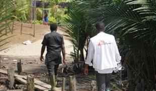 L'équipe MSF composée d'un coordinateur d'urgence, d'un superviseur DMC, d'un responsable de la communication et de volontaires de santé communautaire, marche pour atteindre le village d'Enyenge où ils mènent le deuxième jour de la campagne de vaccination contre le choléra.