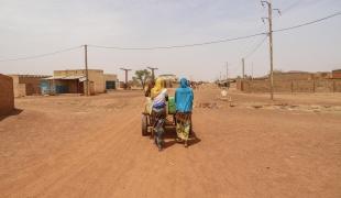 Centre-ville de Djibo - deux femmes poussant une charrette d'eau.