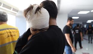 Un enfant blessé par un bombardement aérien dans les bras de son père, après avoir reçu des soins à l'hôpital Al-Shifa. 