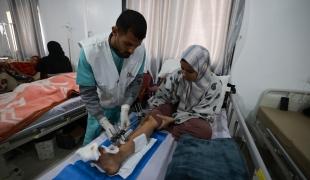Une femme victime d'un bombardement de l'armée israélienne en consultation avec un membre des équipes MSF à l'hôpital indonésien de Rafah. 2024.