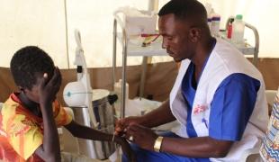 Un infirmier s'occupe d'un patient du service des urgences de la clinique MSF du camp de Zamzam, au Nord Darfour.