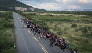 Un groupe de personnes migrantes escorté par des policiers, sur la route reliant les villes de La Venta et Juchitán, dans le sud du Mexique. Octobre 2024
