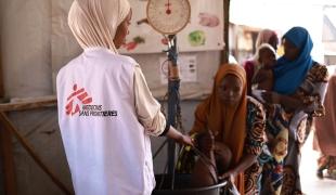  Un membre du personnel MSF prend le poids d'un enfant au centre nutritionnel thérapeutique ambulatoire Kofar Marusa, à Katsina, dans l'État de Katsina.