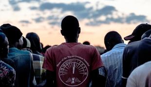 Des hommes font la queue pour recevoir des couvertures distribuées par une association locale aux personnes hébergées dans un abri temporaire pour réfugiés à Musina, en Afrique du Sud, en avril 2021.