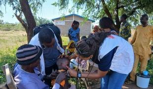 Le médecin référent de l'équipe EURECA examine l'état de santé d'un enfant lors d'une intervention d'urgence dans la région de Kabo.