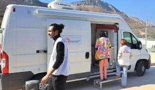 Un agent de santé MSF, accompagne le patient jusqu’à la clinique mobile afin de faciliter la traduction pendant la consultation médicale, Grèce, octobre 2025.