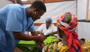 Au centre de santé de MSF, dans le camp de réfugiés de Busuma, des équipes médicales examinent un jeune patient accompagné de sa mère dans la salle de consultation.