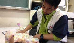 Dans la clinique d'Hakusui Hiroyuki Kato médecin pour MSF prend en charge une fillette de 4 ans souffrant de douleurs à l’estomac.