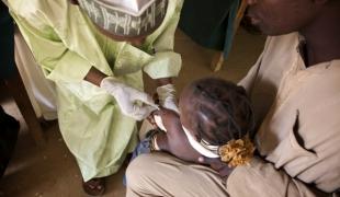 Nigeria : une petite fille est vaccinée contre la rougeole par un employé MSF (2010)