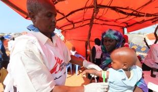 Mesure du périmètre bracchial d'un enfant manutri au Sud de Mogadiscio en Somalie.