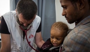 Le Dr Roberto Scaini chef de l’équipe médicale MSF à l'hôpital d'Haydan en consultation avec un jeune patient atteint de pneumonie et de malnutrition modérée.
