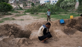 Le fils de Fakhira pleure sa mère enterrée dans un cimetière de Taiz. 2015
