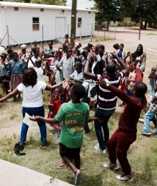Les participants du Teen club dansent et chantent ensemble à la fin de la journée. Mars 2020. Malawi. 