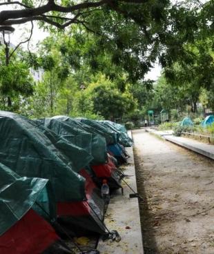 Des mineurs étrangers non accompagnés se reposent dans leurs tentes installées dans un square du 11e arrondissement de Paris.