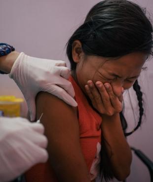 Une jeune fille de Tondo, Manille, est vaccinée gratuitement contre le papillomavirus dans la clinique de Likhaan/MSF. 