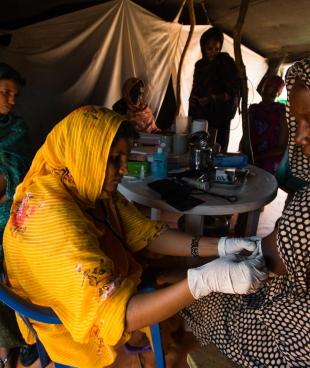 Prise de la tension artérielle d'une patiente dans la tente de maternité de l'hôpital de Médecins Sans Frontières dans le camp de réfugiés maliens de Mbera, en Mauritanie en mars 2013.