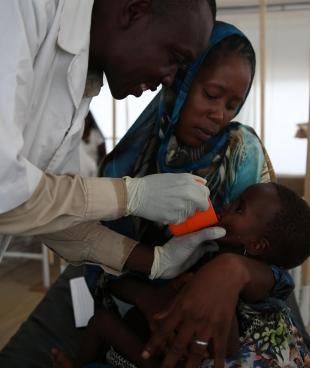 Un enfant pris en charge par un infirmier dans le centre thérapeutique nutritionnel de MSF à N'Djamena. Tchad. 2018.