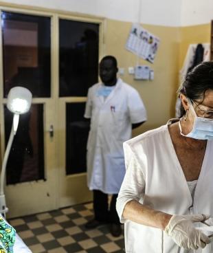 Nathalie Kornfein, infirmière MSF, fournit des soins à une patiente âgée de 76 ans, à l'Hôpital Universitaire du Point G à Bamako. La patiente vivait dans la région de Kayes mais a dû déménager à Bamako pour accéder aux soins oncologiques. Seuls les hôpitaux de la capitale en fournissent. Mali, le 4 septembre 2019.