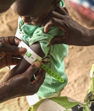 Un membre des équipes MSF mesure le périmère brachial d'un enfant au Niger. 