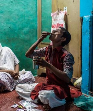 Hanif, un patient atteint de tuberculose multirésistante, prend sa dose quotidienne de médicaments, chez lui, à Mumbai.