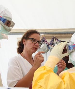 Anja Wolz aide ses collègues à enfiler un kit de protection Ebola lors de la grande épidémie qui a frappé l'Afrique de l’Ouest en 2014-2016.