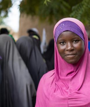 Dans le centre du Mali, une jeune fille attend pour une consultation devant le centre de santé MSF de son village, où des personnes fuyant les combats se sont réfugiées.