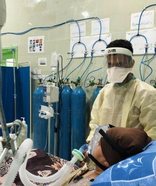 Un membre du personnel médical s'occupe d'un patient dans l'unité de soins intensifs de l'hôpital Al Gamhouria à Aden, mars 2021.