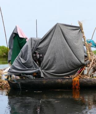 Une famille déplacée a utilisé des couvertures et des bâches en plastique pour construire un abri