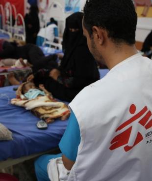 Un membre des équipes MSF de l'hôpital d'Abs, auprès d'un enfant âgé de 3 mois souffrant de malnutrition. Yémen. 2020.