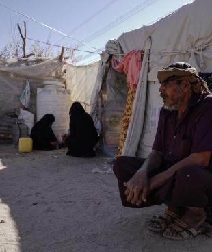 Un homme devant sa tente du camp de personnes déplacées d'Al-Khuseif à Marib au Yémen. Il vit là avec famille composée de 8 personnes. Yémen. 2021.