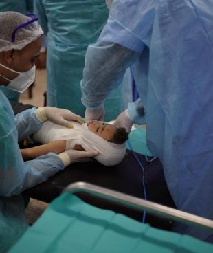 Omar, 20 mois, lors du changement de ses pansements dans la clinique MSF de la ville de Gaza. 2021.