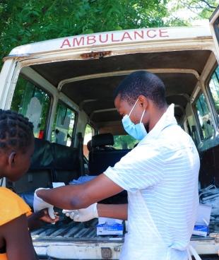 Un employé du ministère de la Santé en discussion avec un patient dans la province de Nsanje où MSF offre un soutien logistique aux personnes déplacées par la tempête Ana. Malawi. 2022.