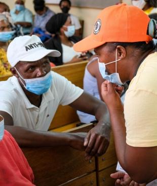 Une membre des équipes MSF de promotion de la santé en discussion avec un patient avant sa consultation. Afrique du Sud.