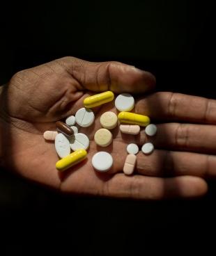 Un homme tient dans sa main ses médicaments contre la tuberculose. Afrique du Sud. 2016.
