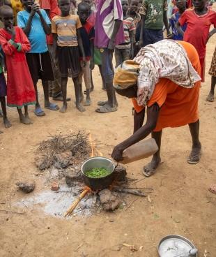 Une femme cuisine des feuilles d'arbres pour tenter de subvenir aux besoins de ses cinq enfants. Soudan du Sud. 2022.