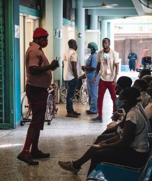 Un membre du personnel soignant parle aux patients dans la zone de triage du centre d'urgence MSF de Turgeau.