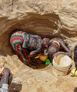 Des femmes cherchent de l'eau dans l'un des puits peu profonds situés le long d'un lit de rivière asséché à Illeret. La sécheresse ravageuse a entraîné une pénurie d'eau dans la région, obligeant les habitants à chercher des sources d'eau alternatives, impropres à la consommation humaine.