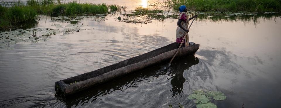 Une femme se déplace à bord d’une barque sur la rivière Zeraf, située près d’Old Fangak. Soudan du Sud, juin 2022