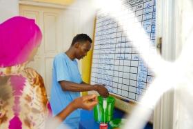 Abdi Bare Abdi, assistant nutritionnel à l'hôpital régional de Bay, soutenu par MSF, mesure le lait thérapeutique pour une mère dont l'enfant est soigné pour malnutrition à Baidoa, en Somalie. Mars 2025 